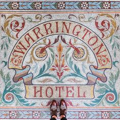 a person sitting on top of a tiled floor next to a sign that says washington hotel