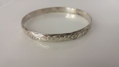 "Flower and leaf design etched into a thick sterling bangle, makes it perfect for stacking.  Stamped Mexico .925 Width: 1/4\" Opening: 2 5/8\" Weight: 16.9g" Stamped Sterling Silver Bangle For Wedding, Sterling Silver Stamped Bangle For Wedding, Etched Sterling Silver Bracelet For Wedding, Elegant Stamped Sterling Silver Bangle, Elegant Sterling Silver Stamped Bangle, Wedding Sterling Silver Stamped Bangle, Vintage Etched Sterling Silver Bangle, Leaf Design, Etching