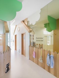 an empty hallway with wooden fence and baby's clothing hanging on hooks