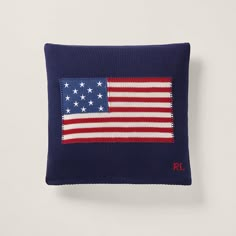 a pillow with an american flag embroidered on the front and side, in navy blue