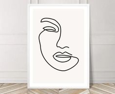 a black and white line drawing of a woman's face on a white wall