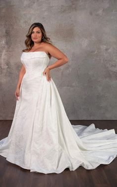 a woman in a white wedding dress posing for the camera with her hands on her hips