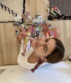 a woman sitting on the floor with candy in her hands