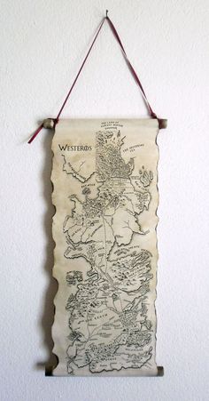 an old map hanging on the wall in front of a white wall with a red string