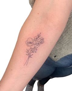 a woman's arm with a flower tattoo on the left side of her arm