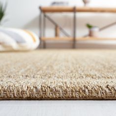 a close up view of a rug on the floor in a room with a bed