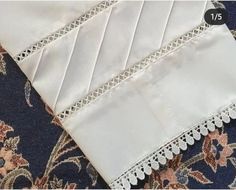 three different types of white lace on fabric