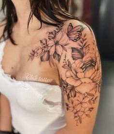 a woman's shoulder with flowers and butterflies tattoo on her left upper half sleeve