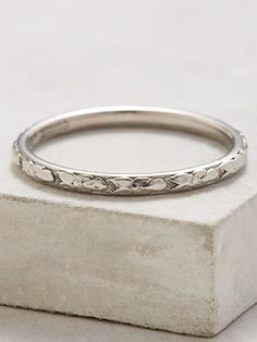 a silver ring sitting on top of a stone block