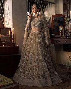 a woman in a bridal gown standing next to a table with candles on it