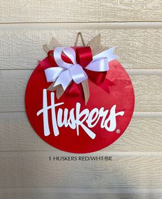 a red sign with the word huskes on it and a bow hanging from it