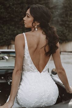 the back of a woman's dress as she sits on top of a car