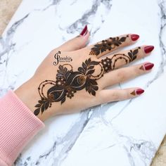 a woman's hand with henna tattoos on it