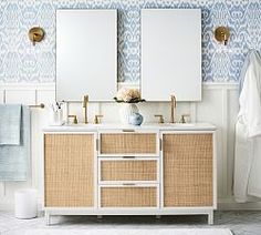 a bathroom with blue and white wallpaper and two mirrors on the side of the vanity