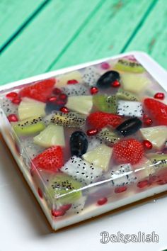 a square glass dish filled with fruit on top of a table