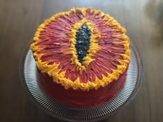 there is a cake that has been decorated with red, yellow and orange icing