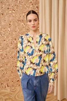 Tailored from textured satin-back crepe, our Greta Blouse features abstract floral ikat motifs that pulse with shades of yellow, cream, and blue. This top has long sleeves that billow slightly, buttoned cuffs, and a notched neckline with a relaxed fit. It�’s the perfect companion to our seasonal denim and tailoring. Composition: 100% Viscose Pair with our Willow Jean and Mini Floret Stud Earring to complete the look. Ikat Motifs, Nyc Boutiques, Notched Neckline, Yellow Cream, Yellow Print, Knit Sweatshirt, Signature Print, Shades Of Yellow, Event Dresses