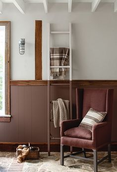 a living room with a chair, window and rugs on the floor in front of it