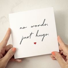 two hands holding a card that says no words just hugs