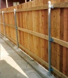 a wooden fence with metal piping attached to it