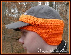 a man wearing an orange crochet hat with a gray cap on his head