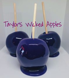 three blue apples with wooden sticks sticking out of them