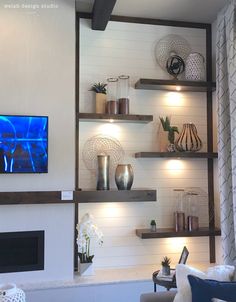 a living room filled with furniture and a flat screen tv mounted on a wall above a fireplace