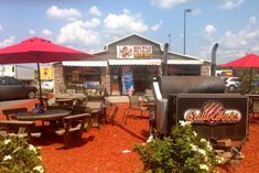 an outdoor restaurant with tables and umbrellas in front of the grillhouse, which is open for business