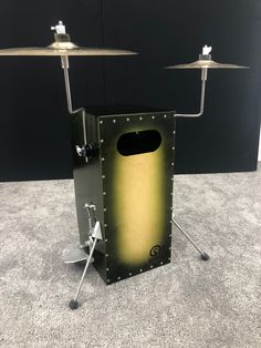 a large metal box with two drums on it's legs and an electronic device in the background