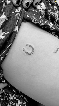 black and white photograph of a woman's stomach with a crescent tattoo on it