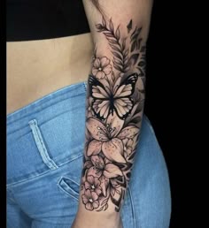 a woman's arm with flowers and butterflies on the left side of her body