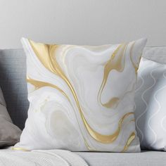 a white and gold marble throw pillow on a couch