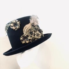 Sometimes that touch of eccentricity is just what you need to set yourself apart from the crowd and nothing will let you do so better than a great head topper, one like this Neo-Victorian top hat. Combining a vintage Victorian style with the mechanical aesthetic of steampunk, this unisex top hat is fitted with a variety of Victorian vintage baubles and fantastical cogs & gear ornaments on a formed Felt hat with with Ribbon Band. Choosing the custom theme Hat option? Whether you are a high-so Handmade Fitted High Crown Mini Hats, Handmade Fitted Mini Hat With High Crown, Steampunk Top Hat With Curved Brim For Costume, Victorian Adjustable Top Hat With High Crown, Steampunk Festival Hat Band, Steampunk Mini Hat With Curved Brim For Festivals, Steampunk Curved Brim Mini Hat For Festivals, Steampunk Fitted Hat With Short Brim, Steampunk Fitted Brimmed Top Hat