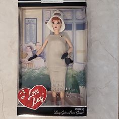 a barbie doll in a box with a heart on the front and an image of a woman's head