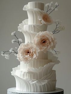 a three tiered white cake with flowers on top