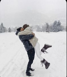 a man and woman kissing in the snow