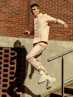 a young man is jumping up and down the stairs in front of a brick building