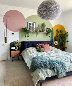 a bedroom decorated in pastel colors with plants on the wall and hanging decorations above the bed