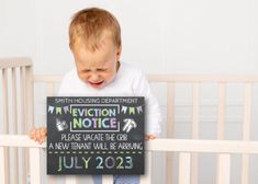 a little boy holding up a sign that says eviction notice to the new infant will be around july 202