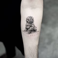 a black and white photo of a person's leg with a tattoo on it