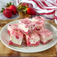 strawberry cheesecake bars on a plate with strawberries in the background