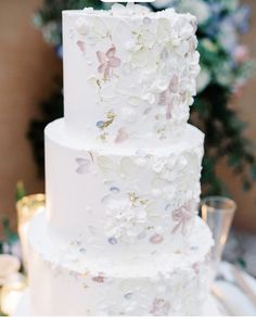 a white wedding cake with flowers on it