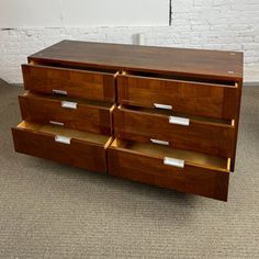 a large wooden dresser with three drawers on each side and two white tags on the bottom