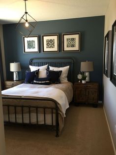 a bed sitting in a bedroom next to two framed pictures on the wall above it