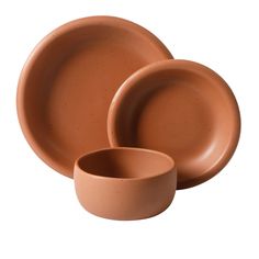 three brown bowls and two plates on a white background