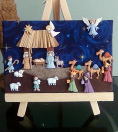 a nativity scene is displayed on a wooden easel