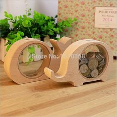 two wooden letters with coins in them on a table