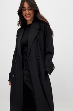 This trenchcoat features a long fit and a lapel neckline. It has a button-up detail at the shoulders and at the cuffs and a double-breasted button design. Our trenchcoat has a self tie waist belt, welt side pockets and a back slit detail. Trench Noir Outfit, Black Trenchcoat Outfit, Trench Coats Women Outfit, Black Trenchcoat, Mantel Outfit, Trench Coat Black, Button Design, Casual Style Outfits, Style Outfits