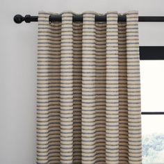 the curtain is hanging in front of a window with black metal rods and striped fabric