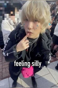 a boy with piercings on his nose and hand in front of him, while he is